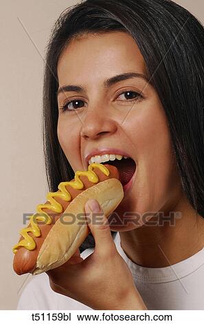 Woman eating hot dog View Large Photo Image Stock Image - Woman eating hot dog. Fotosearch