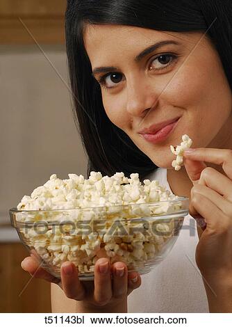 Stock Image - Woman eating popcorn. Fotosearch