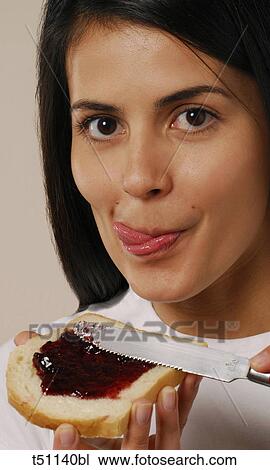 Woman eating spreading jam on bread View Large Photo Image Stock Image - Woman eating spreading jam on bread. Fotosearch
