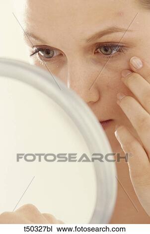 Woman examining herself in the mirror View Large Photo Image Stock Image - Woman examining herself in the mirror. Fotosearch