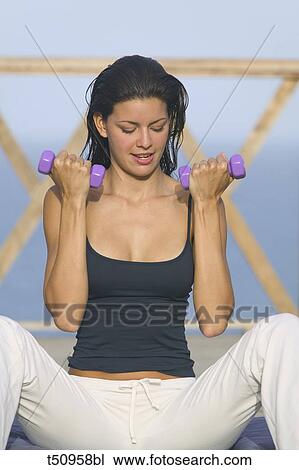 Woman exercising with dumbbells View Large Photo Image Stock Image - Woman exercising with dumbbells. Fotosearch