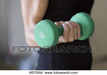 Woman holding dumbbell View Large Photo Image Stock Image - Woman holding dumbbell. Fotosearch