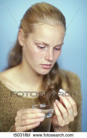 Woman holding pill and glass View Large Photo Image Stock Image - Woman holding pill and glass. Fotosearch