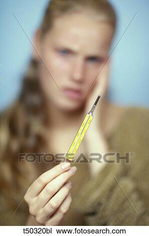 Woman looking at thermometer View Large Photo Image Stock Image - Woman looking at thermometer. Fotosearch