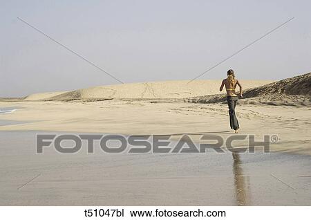 Woman running on beach View Large Photo Image Stock Image - Woman running on beach. Fotosearch