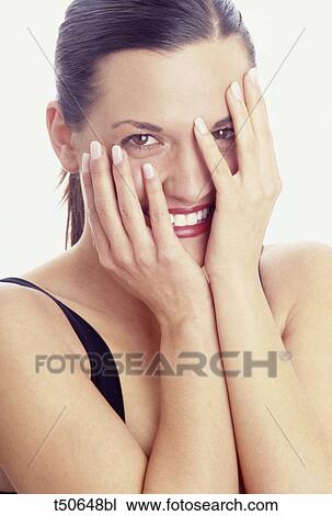 Woman smiling with hands over face View Large Photo Image Stock Image - Woman smiling with hands over face. Fotosearch