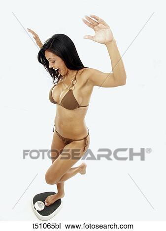 Woman standing on scales View Large Photo Image Stock Image - Woman standing on scales. Fotosearch