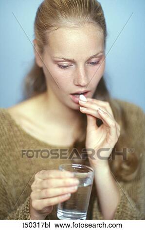 Stock Image - Woman taking medicine. Fotosearch
