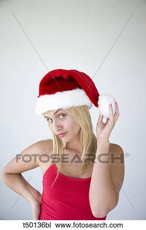 Stock Image - Woman wearing Santa Claus hat. Fotosearch
