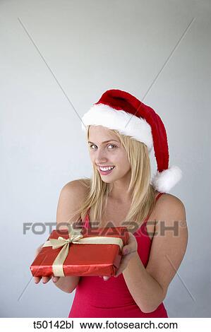 Woman wearing Santa Claus hat with gift View Large Photo Image Stock Image - Woman wearing Santa Claus hat with gift. Fotosearch