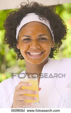 Woman with face mask holding glass with orange juice View Large Photo Image Stock Image - Woman with face mask holding glass with orange juice. Fotosearch
