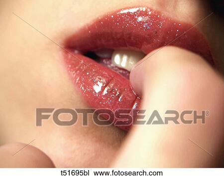 Stock Image - Woman with finger in mouth. Fotosearch