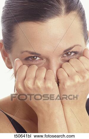 Woman with fist over her mouth View Large Photo Image Stock Image - Woman with fist over her mouth. Fotosearch