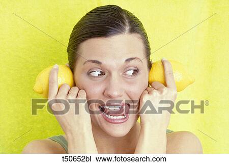 Woman with lemons on her ears View Large Photo Image Stock Image - Woman with lemons on her ears. Fotosearch
