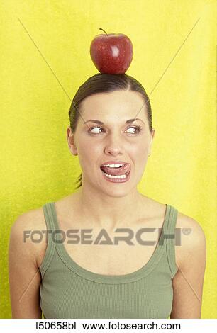 Woman with red apple on head View Large Photo Image Stock Image - Woman with red apple on head. Fotosearch
