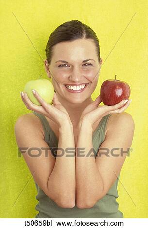 Woman's portrait holding two apples View Large Photo Image Stock Image - Woman's portrait holding two apples. Fotosearch