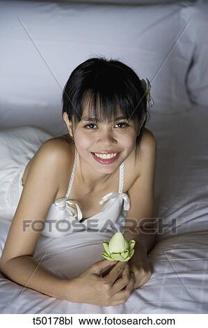 Woman's portrait lying on bed View Large Photo Image Stock Image - Woman's portrait lying on bed. Fotosearch