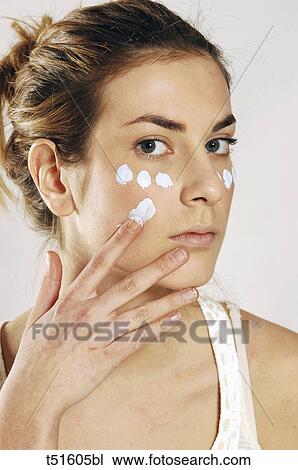Woman's portrait with applying cream on her face View Large Photo Image Stock Image - Woman's portrait with applying cream on her face. Fotosearch