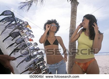Women trying on sunglasses View Large Photo Image Stock Image - Women trying on sunglasses. Fotosearch
