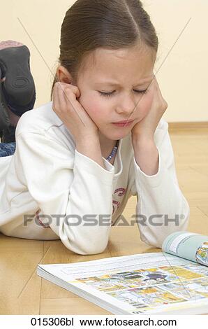 young girl lying on floor reading textbook View Large Photo Image Stock Image - young girl lying on floor reading textbook. Fotosearch