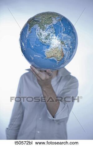 Young man holding a globe View Large Photo Image Stock Image - Young man holding a globe. Fotosearch