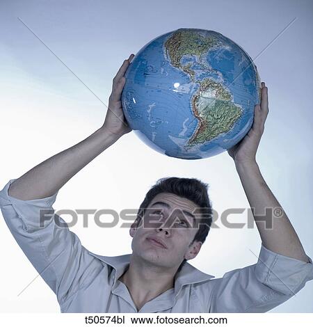 Young man holding a globe View Large Photo Image Stock Image - Young man holding a globe. Fotosearch