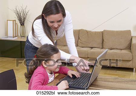 young mother showing little daughter how to work with laptop computer View Large Photo Image Stock Image - young mother showing little daughter how to work with laptop computer. Fotosearch