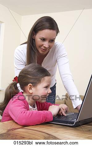 young mother showing little daughter how to work with laptop computer View Large Photo Image Stock Image - young mother showing little daughter how to work with laptop computer. Fotosearch