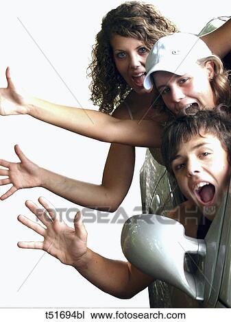 Stock Image - Young people in car waving hands. Fotosearch
