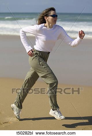 Young woman running on the beach View Large Photo Image Stock Image - Young woman running on the beach. Fotosearch