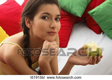 Stock Image - Close-up of a teenager girl eating an apple . Fotosearch