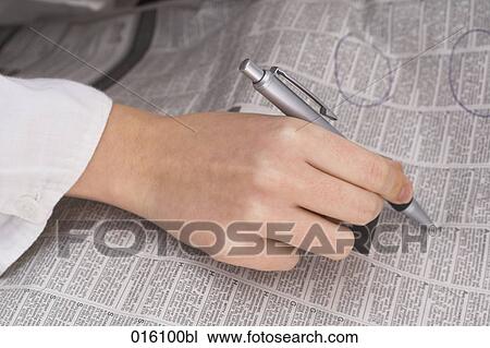 close-up of female hand holding pen marking classified ads View Large Photo Image Stock Image - close-up of female hand holding pen marking classified ads. Fotosearch