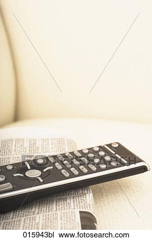 close-up of newspaper and remote control on arm chair View Large Photo Image Stock Image - close-up of newspaper and remote control on arm chair. Fotosearch