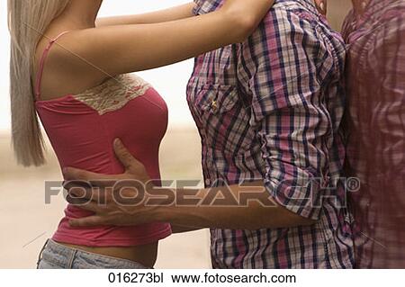 Stock Image - detail of young couple embracing. Fotosearch