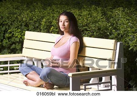 full body portrait of pregnant young woman sitting on park bench View Large Photo Image Stock Image - full body portrait of pregnant young woman sitting on park bench. Fotosearch