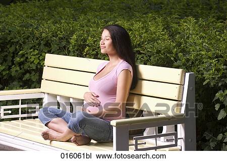 full body portrait of pregnant young woman sitting on park bench View Large Photo Image Stock Image - full body portrait of pregnant young woman sitting on park bench. Fotosearch