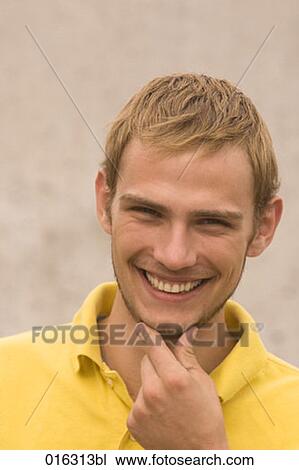 headshot of young man giving a mischief smile View Large Photo Image Stock Image - headshot of young man giving a mischief smile. Fotosearch