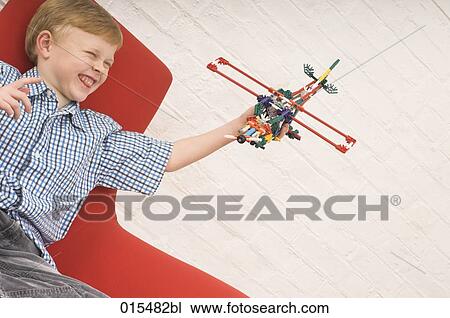 joyous young boy playing with toy airplane View Large Photo Image Stock Image - joyous young boy playing with toy airplane. Fotosearch