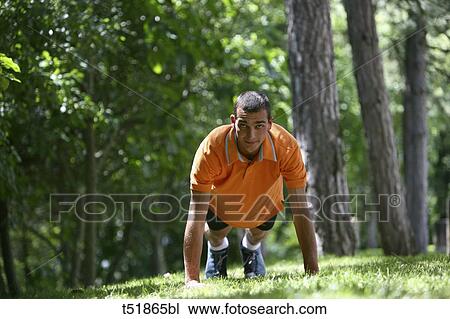 Stock Image - Man doing push-ups outdoors . Fotosearch