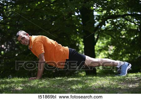 Stock Image - Man doing push-ups outdoors . Fotosearch