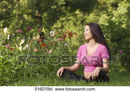 portrait of pregnant young woman sitting on meadow in park View Large Photo Image Stock Image - portrait of pregnant young woman sitting on meadow in park. Fotosearch
