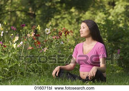 portrait of pregnant young woman sitting on meadow in park View Large Photo Image Stock Image - portrait of pregnant young woman sitting on meadow in park. Fotosearch