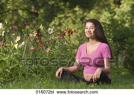 portrait of pregnant young woman sitting on meadow in park View Large Photo Image Stock Image - portrait of pregnant young woman sitting on meadow in park. Fotosearch