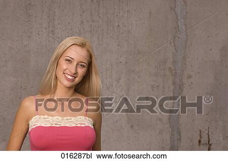 Stock Image - portrait of smiling blonde wearing pink top . Fotosearch