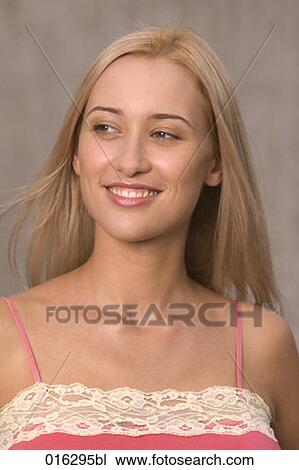 Stock Image - portrait of smiling blonde weariung pink top. Fotosearch