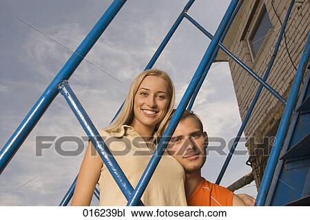 portrait of smiling young couple looking through railing View Large Photo Image Stock Image - portrait of smiling young couple looking through railing. Fotosearch
