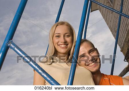 portrait of smiling young couple looking through railing View Large Photo Image Stock Image - portrait of smiling young couple looking through railing. Fotosearch