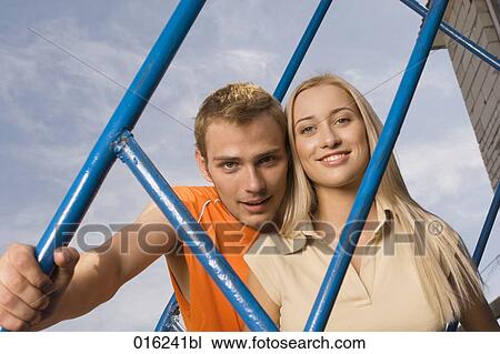 portrait of smiling young couple looking through railing View Large Photo Image Stock Image - portrait of smiling young couple looking through railing. Fotosearch