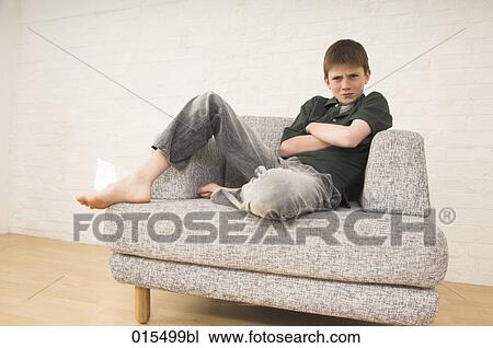 portrait of sulking young boy sitting in arm chair View Large Photo Image Stock Image - portrait of sulking young boy sitting in arm chair. Fotosearch
