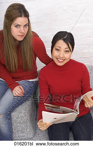portrait of two young women reading magazine together one looking jealous View Large Photo Image Stock Image - portrait of two young women reading magazine together one looking jealous. Fotosearch